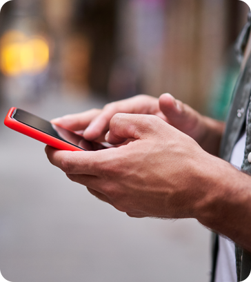 A person holding a cell phone in their hands.