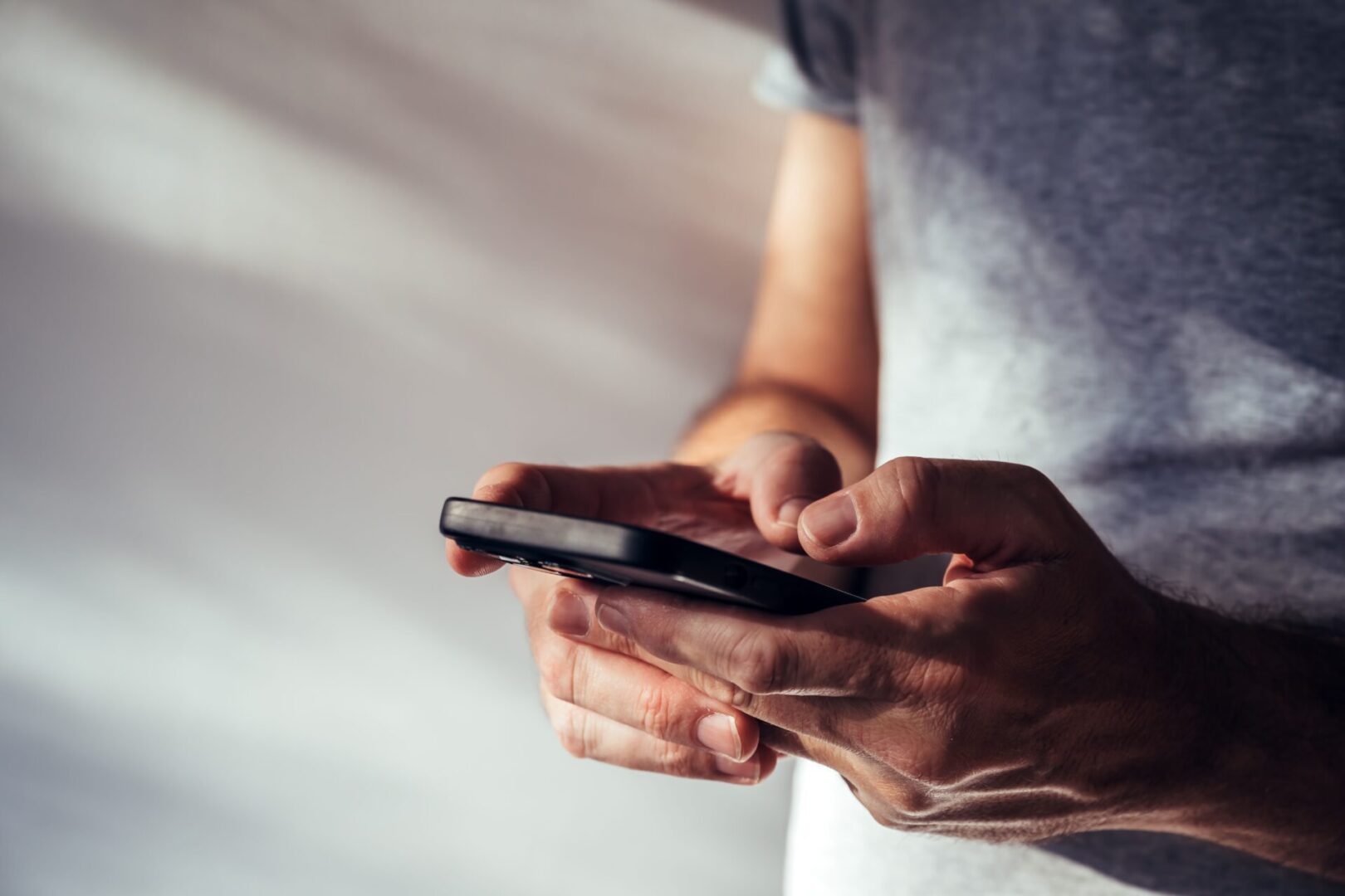 A person holding a cell phone in their hands.