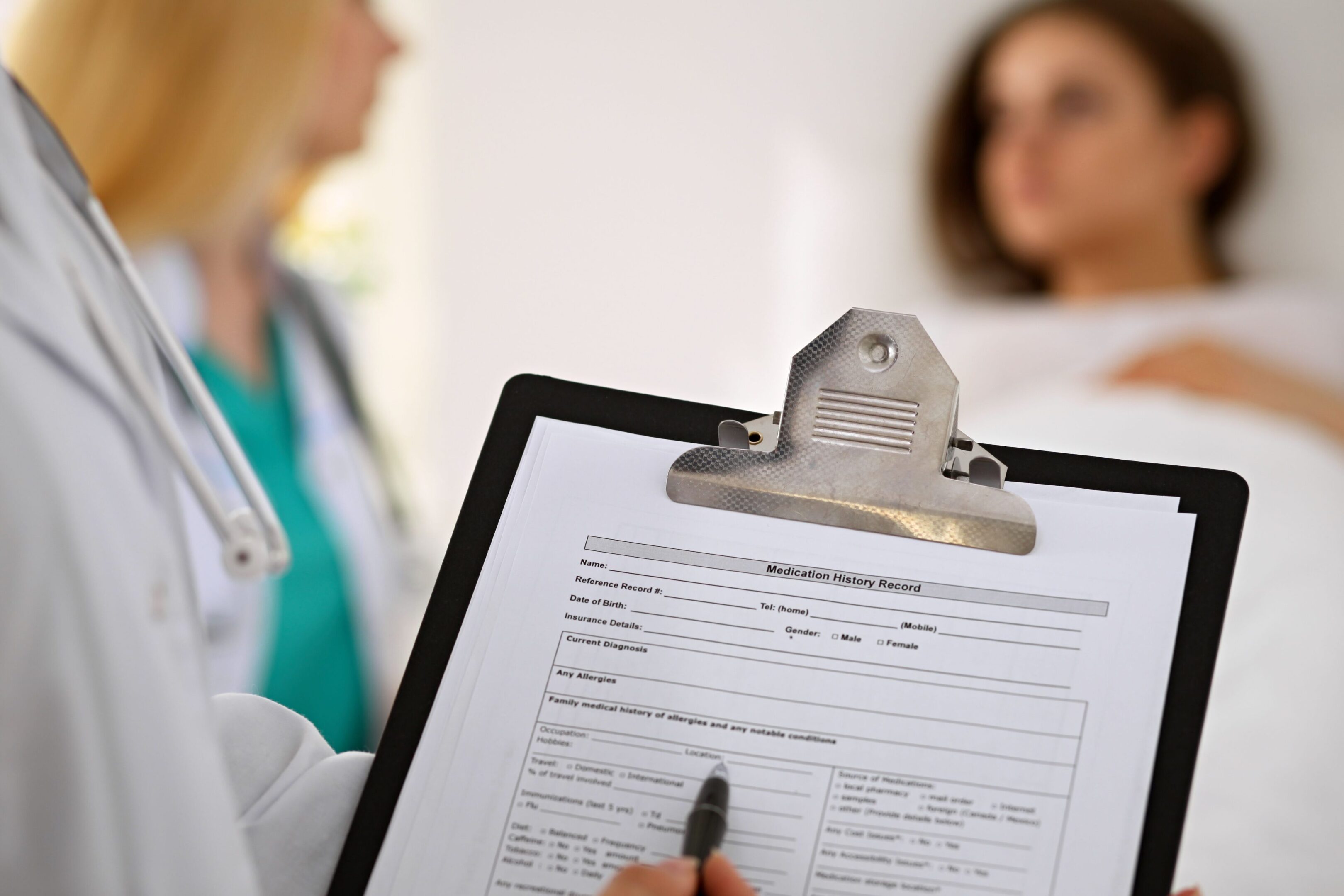 A doctor holding a clipboard with medical records on it.