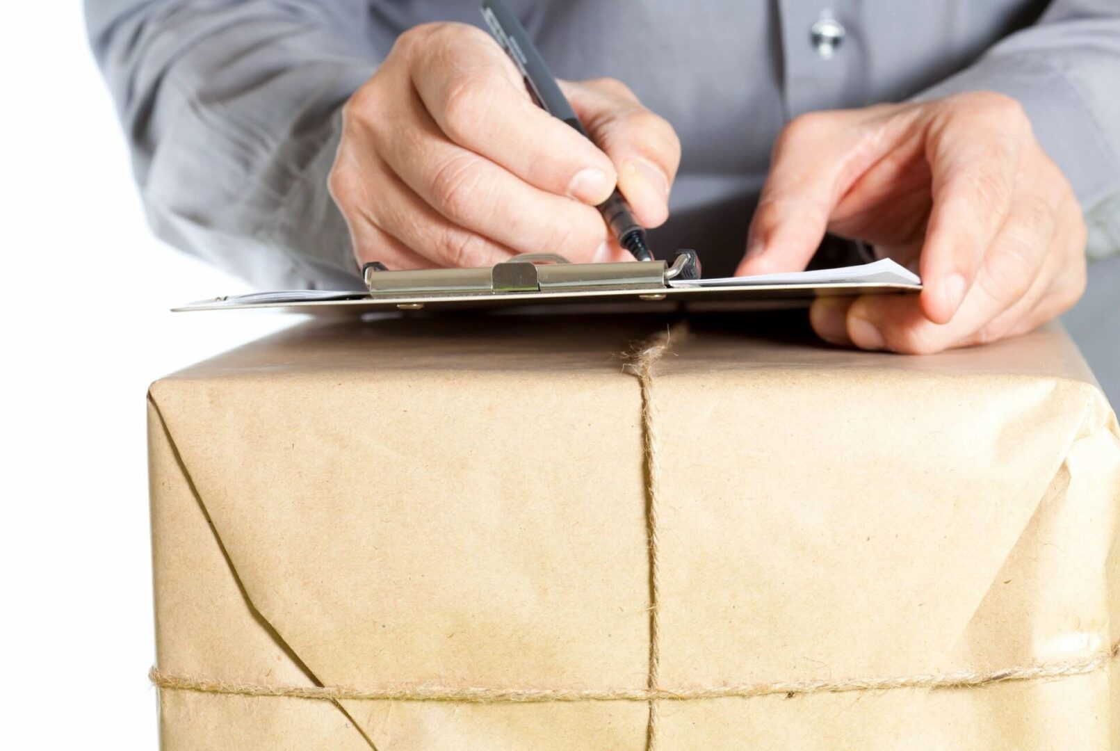 A person writing on paper with pen and tablet.