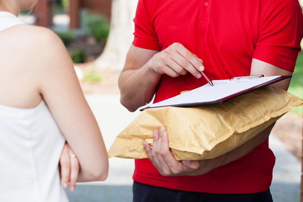 A person holding onto some food while standing next to another person.